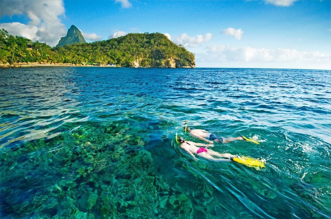 Couple snorkeling at Anse Chastanet with Pitons backdrop